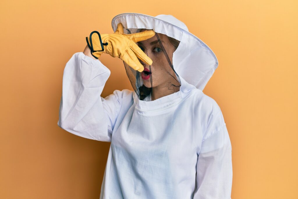 female woman beekeeper peeking in bee suit